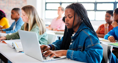 Student using a laptop in a classroom setting