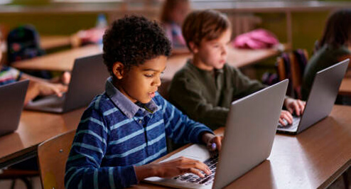 Student using a laptop in a classroom setting