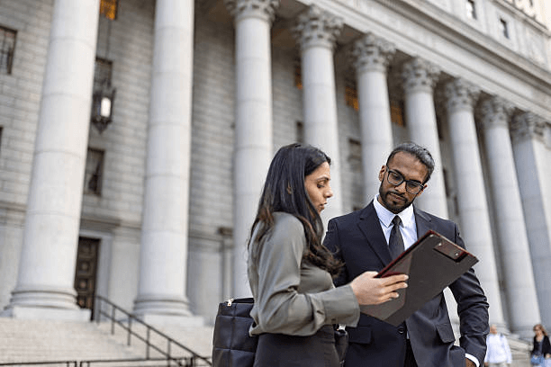Two professionals speaking outside a government building